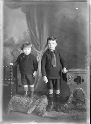 Studio portrait of two unidentified boys standing next to each other on an animal skin, probably Christchurch district