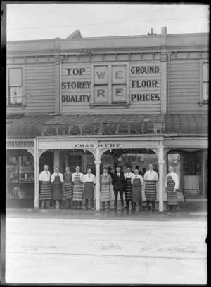 Ten men in butchers aprons and a man in a business suit, all unidentitified, standing outside the premises of Chas Were butchery, possibly Christchurch district