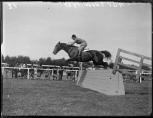 Autumn Show, view of a man and horse jumping a fence within a competition, with other riders looking on, Te Aute, Hawke's Bay District