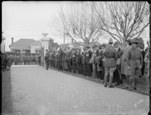 Veterans rally, returned servicemen with medals lined up along a driveway as an honourguard, awaiting the visit of [Lord Bledisloe, the Governor General?], soldiers on the street beyond, Hawke's Bay District