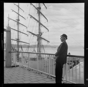 Unidentified man in front of sailing ship ARC Gloria, berthed at overseas terminal, Wellington Harbour