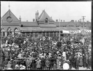Large crowd of people gathered outside the Christchurch Railway Station with a 'Welcome Home' banner probably to welcome the returning troops from World War One