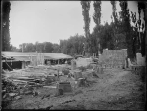 Timber mill, with sawn timber stacked and lying around, mill worker using machinery, [Hastings?], Hawke's Bay District
