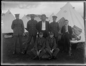 A group of unidentified soldiers standing in front of a tent, at casual camp, Hastings