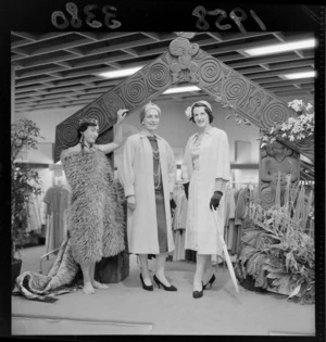 Fashion display with fake Maori backdrop at Kirkcaldie & Stains department store, Wellington, featuring models in coats and a woman in traditional Maori dress