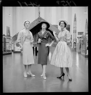 Three unidentified women modelling outfits including hats in the Dominion Museum, Wellington