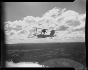 A Supermarine Walrus amphibious biplane, in flight over an unidentified location