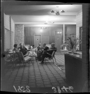Unidentified group seated in lobby of Ohakune Hotel, Ruapehu District, including smoking and coffee drinking