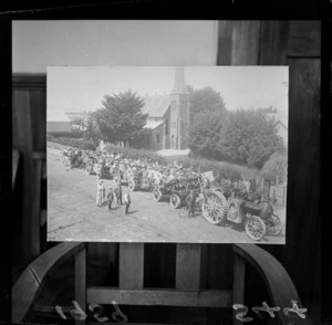 A patriotic procession of children with flags on carts being towed by a traction engine in Masterton, Southern Wairarapa