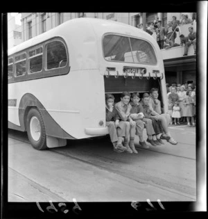 Five unidentified boys and dog, sitting in external rear luggage compartment of a bus in Festival of Wellington parade, [Manners Street?], Wellington