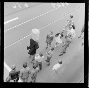 Unidentified child spectators and a performer wearing a paper-maiche head, at the Festival of Wellington parade, Wellington