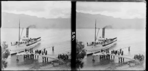 Paddle steamer Earnslaw about to dock at Elfin Jetty, which has passengers waiting on it, Lake Wakatipu, Queenstown District