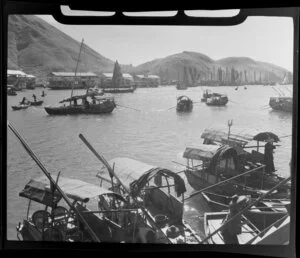 Waterfront street scene, Hong Kong, featuring sampans (traditional Chinese sightseeing boats) and including junks