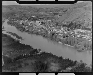 Close-up view of Roxburgh, Central Otago, within the Clutha River Valley, showing Scotland Street (State Highway 8) with church and school amongst residential housing, and pine plantation across river from town