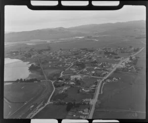 Waikouaiti, Otago District, view over town showing Palmerston-Waikouaiti Road (State Highway 1) with racecourse next to Hawksbury Lagoon wildlife refuge, surrounded by farmland, with Karitane Inlet with hills beyond
