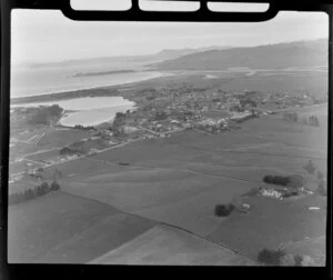 Waikouaiti, Otago District, view over town showing Palmerston-Waikouaiti Road (State Highway 1) with racecourse next to Hawksbury Lagoon wildlife refuge, surrounded by farmland, with Waikouaiti Beach and Karitane Inlet with hills beyond