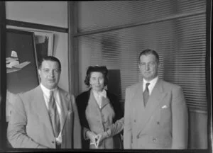 Two unidentified men and a woman standing in an office