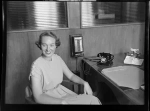Miss Douglas sitting in office with desk and phone