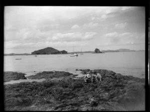 Children exploring on beach rocks, Paihia, Bay of Islands
