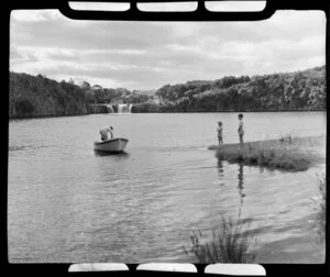 View of Haruru Falls, boys watching man in boat at lake, Waitangi, Bay of Islands