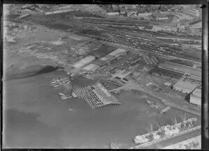 Cargo ships, stacked timber and car ferry, wharf for exports, Auckland