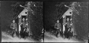 Brothers Owen William and Edgar Richard Williams holding guns and with dead rabbits outside playhouse (which has electricity), Dunedin area, Otago Region