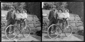 Unidentified man holding bicycle on which brothers Owen William (front) and Edgar Richard Williams sit on garden path at the Williams' Royal Terrace home, Kew, Dunedin, Otago Region