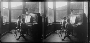 Brothers Edgar Richard (left) and Owen William Williams seated at piano playing duet, Williams' Royal Terrace house, Kew, Dunedin, Otago Region