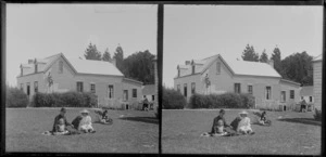 Family group with dogs, house in the background, Taieri area, South Otago