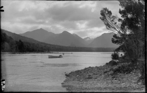 Two men in a boat, which is flying the Union Flag from stern, [Fiordland National Park, Southland District?]