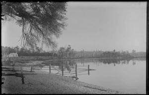 River or estuary with a wooden fence and small house beside it