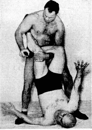John Katan, the Canadian wrestler, who caused a sensation by beating Sergeant Blom field in his first New Zealand bout at the Wellington Town Hall this week, demonstrates one of his specialty holds, a standing inside Japanese toe hold. (Evening Post, 04 May 1940)