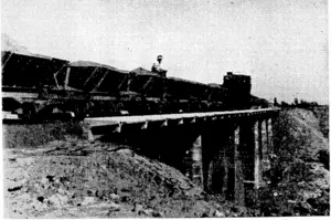 C. B. Hornig Photo. One of the first trains passing over the recently-completed- Kopuawhara. River bridge, on the East Coast Main Trunk Railway, south of Gisborne. • (Evening Post, 06 May 1940)