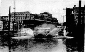 ETcning Post" Photfl These ■■ pictures were •■ taken. during – the downpour at midday yesterday, ■ and show motor-cars ploughing through the flooded Thorndon Quay, near the railway-station, and pedestrians trappedon a pavement-awash opposite the Magistrate's Court. y (Evening Post, 10 May 1940)