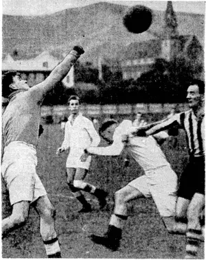 5. Ward, Waterside goalkeeper, punches the ball clear as a Marist forward (in. stripes) threatens his citadel in their match at the Basin Reserve last Saturday. The other players are Waterside men, playing in white to avoid confusion with Marist. (Evening Post, 11 May 1940)