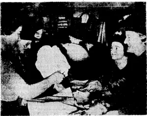 Evening Post" Photo. Purchasers at the Red Cross shop in Willis Street looking for bargains. Yesterday members of the League of Mothers were in charge of the shop, which is run by the Order of St. John Women's War Committee. (Evening Post, 07 June 1940)