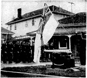 While a company of sailors present arms, the White Ensign is hauled skyward at the Royal Canadian Naval Barracks on tlie west coast of the great '■ Dominion. (Evening Post, 06 July 1940)