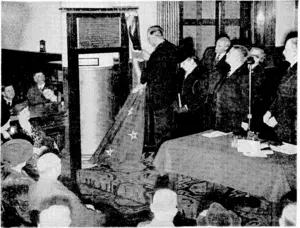 Evening Post t'hoto. The Governor-General unveiling a bronze commemorative tablet in the main banking chamber of the Union Bank of Australia, Lambton Quay, yesterday afternoon, to mark the centennial of the commencement of the bank's business in New Zealand. The tablet will later be placed on the Featherston Street frontage of the bank. Beside the table are the Hon. W. Nash, Minister of Finance, and Mr. T. C. A. Hislop, Mayor of Wellington. At the back is Mr. Leslie Lefeaux, Governor of the Reserve Bank. (Evening Post, 08 March 1940)