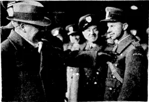 Sport and General" Photo. Sir Kingsley Wood, Secretary of State for Air, pointing to the word 'Poland" on the shoulder of a Polish air officer who escaped from ' his country after the German invasion, and, with other Poles, has joined the R.A.F. (Evening Post, 11 March 1940)
