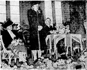 Evening Post" Photo. Mrs. Fraser, wife of the Prime Minister, speaking at the Technical College Fair in St. Mark's Church Hall this week, which she opened. Seated at the table is the principal of the college, M,r. R. G. Ridling, and to the left is Mrs. Ridling and on the right Mrs. M. J. Bentley, president of the auxiliary. (Evening Post, 18 October 1940)