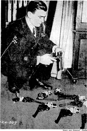 A petty-officer aboard a British destroyer preparing pistols $ for a boarding party. These weapons are kept in the gun-racks and are issued just before the order is given to board the enemy. Each pistol has a lanyard, by which it is fastened to the man's clothing. (Evening Post, 01 November 1940)