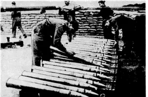 Central Press Photo. An officer in command of an anti-aircraft battery in a London suburb, checking over the ammunition ivhile the gun is being cleaned in readiness for another barrage. During recent night raids enemy aircraft have met some of the fiercest barrages ever known, and have repeatedly been driven back from their targets. (Evening Post, 19 November 1940)