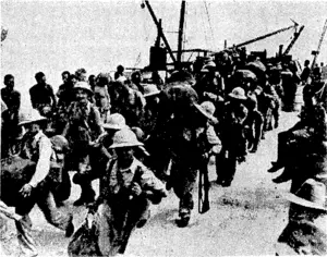 Hcltneied American troops disembarking at Port Moresby, New Guinea. Each man is carrying his barracks bag, equipment, and ' & ?s&*kf; fo*"'Mistanf> fighting. (Evening Post, 04 November 1942)