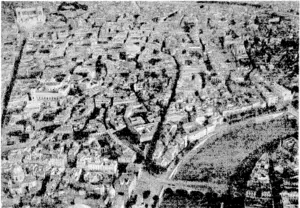 An aerial view of the centre of Rome, ivilh the River Tiber and two of its many bridges, in the right foreground. The large building (top left) is the Victor Emmanuel Monument, and just below if, to the right is the Palazzo tenezia, which used to be Mussolini's headquarters. , (Evening Post, 05 June 1944)