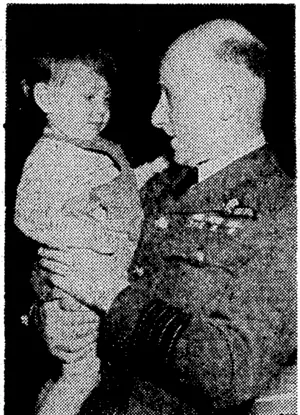 Official R.N.Z.A.F. Photo. Group Captain T. W. White, head of the New Zealand Air Mission, Ottawa, recently paid a visit to a gathering of the New Zealand Wives' Association at the Fort Garry Hotel, Winnipeg, and is here seen with the small son of L.A.C. N.^ Ricliardson, a New Zealander stationed at the Air Observers' School at Winnipeg. (Evening Post, 26 June 1944)