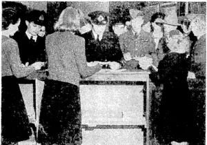 New Zealand servicemen call for their mail. A scene at the counter of the New Zealand Army Post. Office in'London. (Evening Post, 29 July 1944)