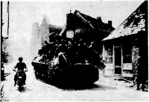 A Sherman tank, loaded with British infantrymen, parsing through the devastated streets of Caumont in pursuit of the Germans. (Evening Post, 26 September 1944)