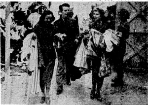 Arriving at a place in France where they are to give a performance, girls of a British concert party take their costumes to a dressingroom, passing a captured enemy gun as they do so. (Evening Post, 27 September 1944)