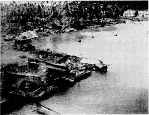 Buildings surrounding the wharves on Butaritari Island, Makin Atoll, after the aerial bombardment preceding its capture by American forces. A big crater can be seen at the end of one of the quays. (Evening Post, 13 January 1944)