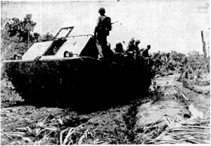 An amphibious tank, carrying United States marines to the fighting lines in the Solomons, ploughing through the heavy mud of a jungle clearing on Bougainville. (Evening Post, 15 January 1944)